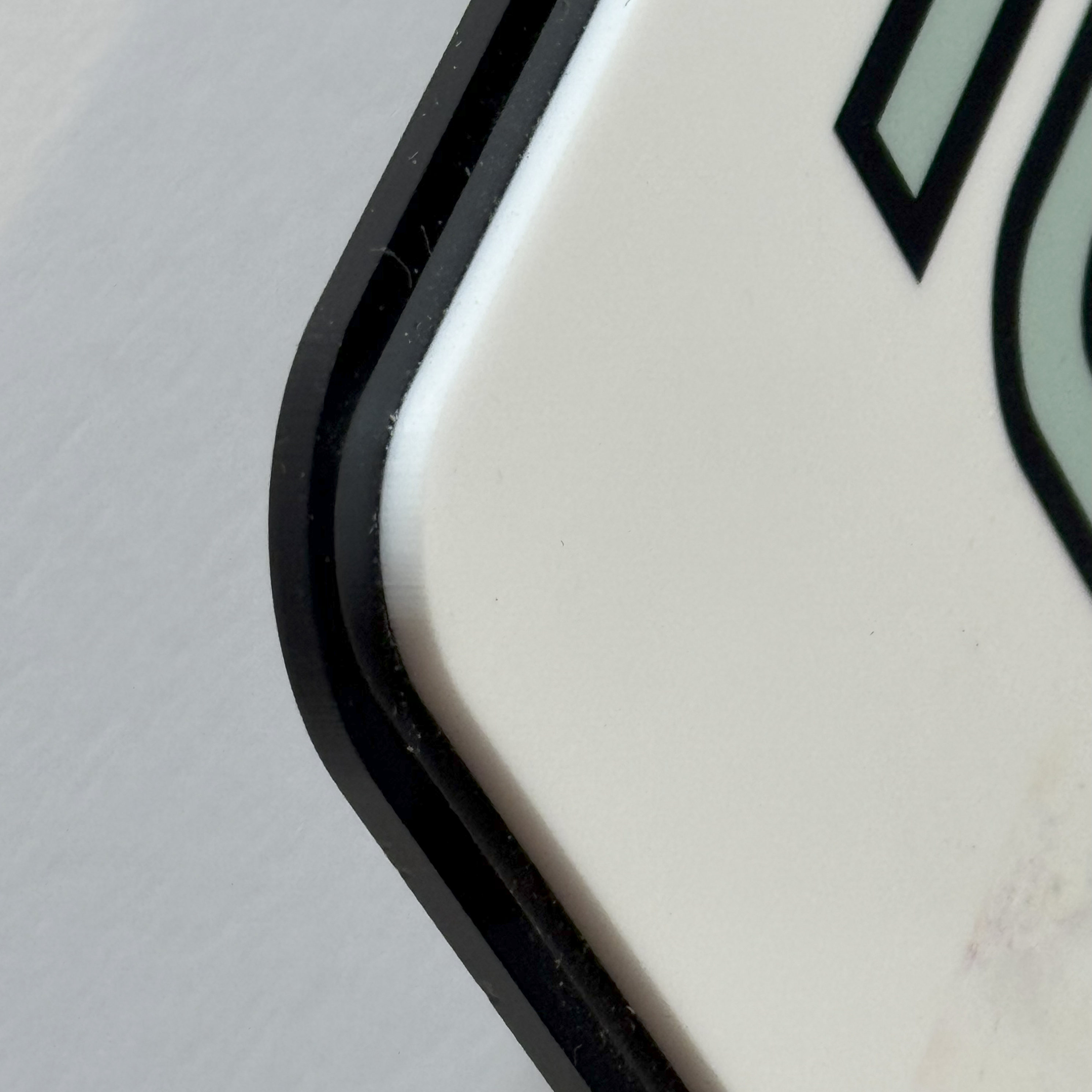 A car show board being tested for durability, showing its resistance to scratches, water, and fading.